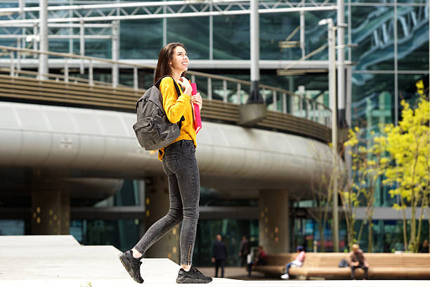 istock Smiling college student walking on college campus with bag 618531976