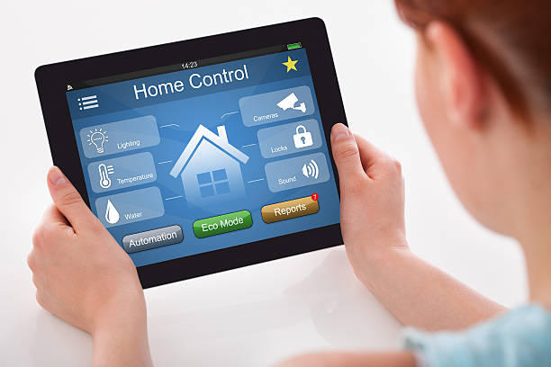 istock Woman Holding Digital Tablet With Remote Home Control System 618532612