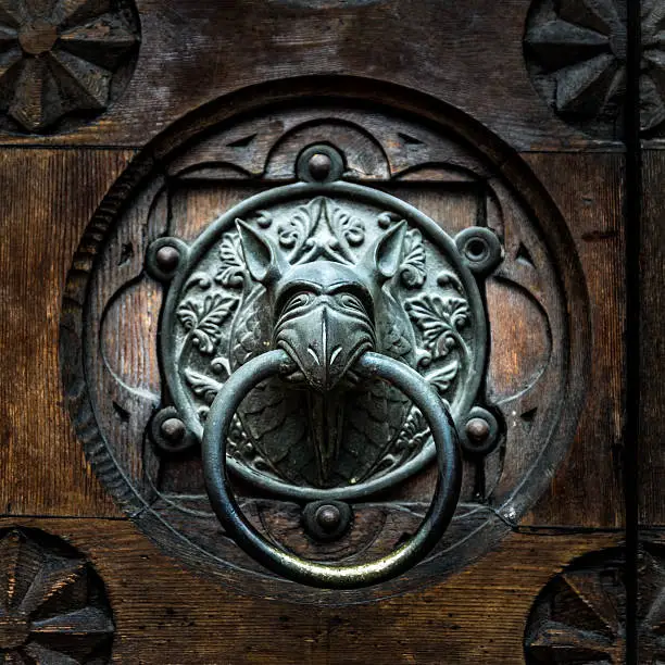 Antique door knocker shaped like monster's head.