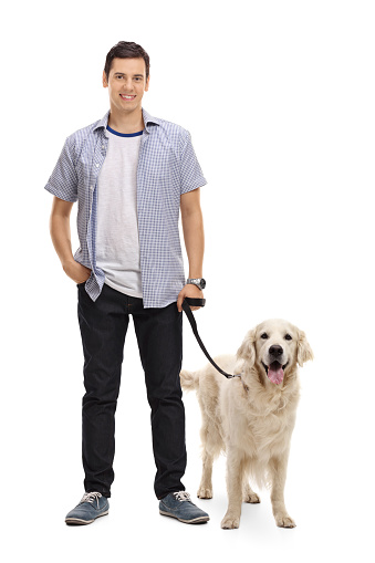 Full length portrait of a young man posing with his dog isolated on white background