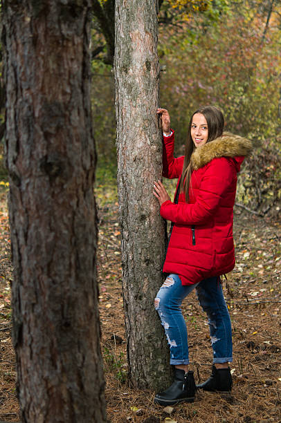 istock Young woman alone on a forest wearing  red overcoat 618535154