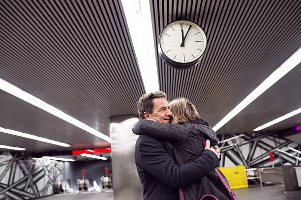 istock Senior couple standing at the underground platform, hugging 618536464