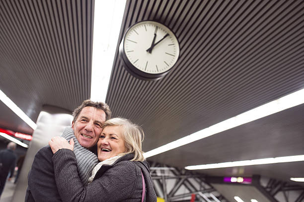 istock Senior couple standing at the underground platform, hugging 618536508