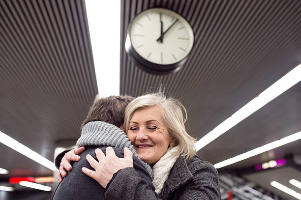 Senior couple standing at the underground platform, hugging
