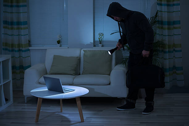 istock Robber Holding Flashlight Over Laptop At Home 618537328