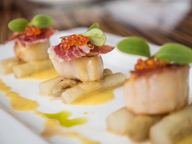 istock Seared scallops with salmon roe, ham and asparagus 618539528