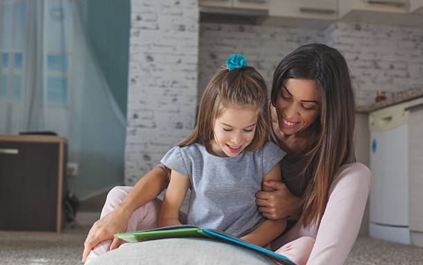 istock Cute mother and daughter reading book 618539596