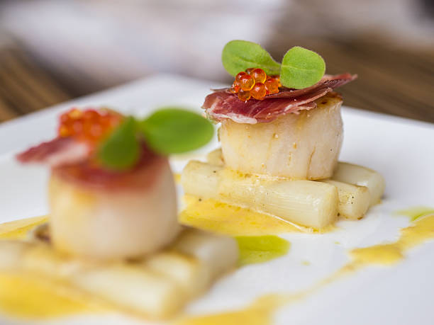 istock Seared scallops with salmon roe, ham and asparagus 618539680