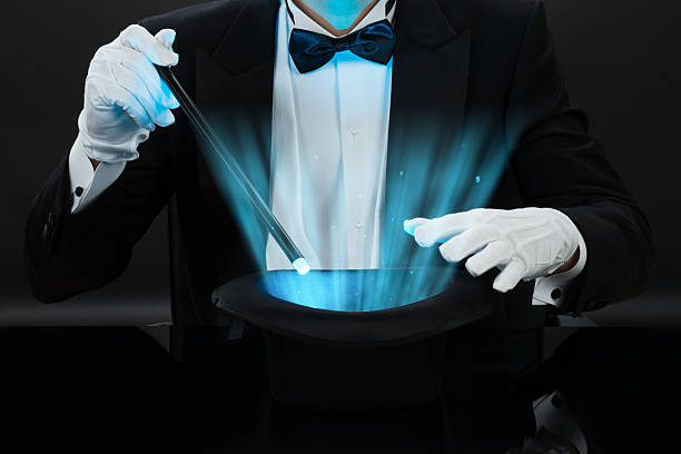 istock Magician Holding Magic Wand Over Illuminated Hat 618539928