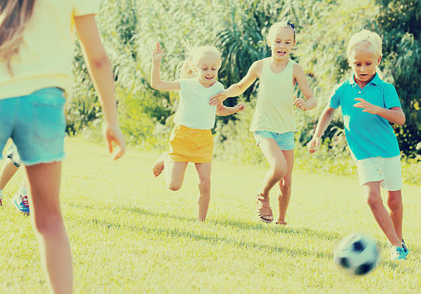 istock children playing football on meadow 618541426