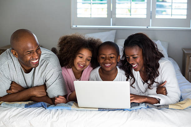 istock Family using laptop on bed 618544216