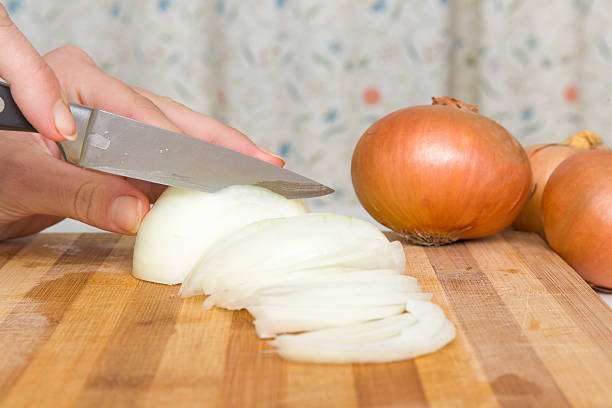 istock Woman's hand with a knife cuts the onion. Healthy eating. 618546514