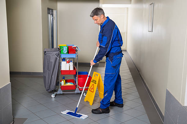 männliche arbeiter mit besen reinigung corridor - hausmeister stock-fotos und bilder