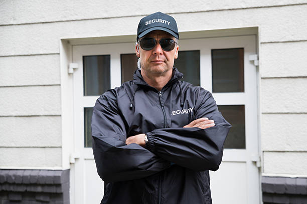 istock Security Guard Standing Arms Crossed Outside Building 618548588
