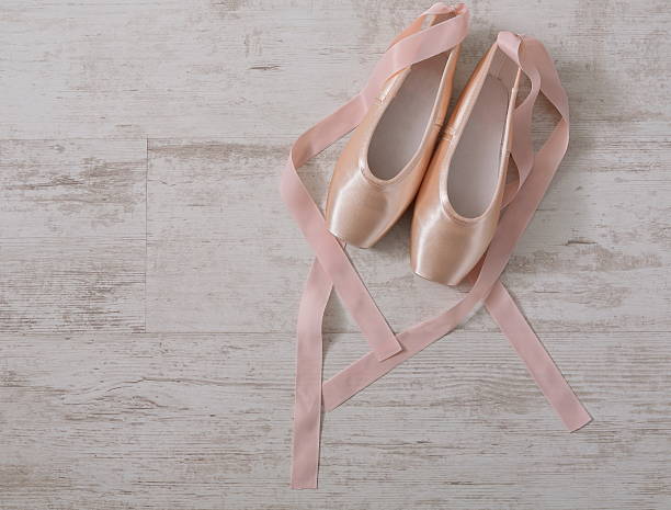 istock Pink ballet pointe shoes on white wood background 618550546