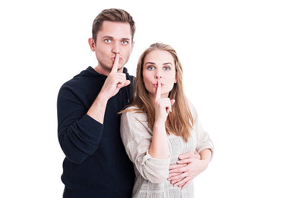 istock Cute couple making shush gesture with index finger 618550754