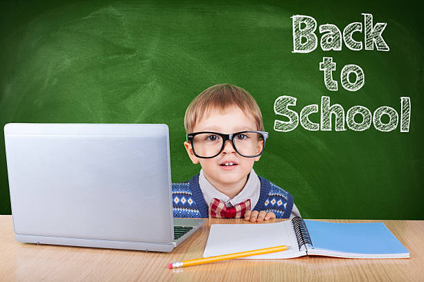 istock Child with laptop peeking in the classroom 618552230