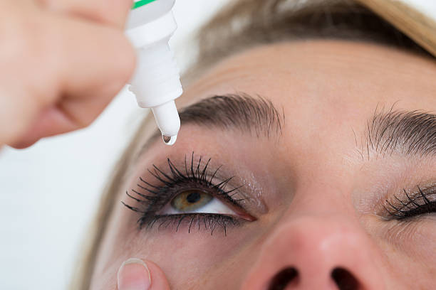 istock Woman Applying Eye Drop Over White Background 618552682