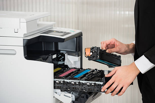 biznesmen mocujący kasetę w drukarce w biurze - cartridge zdjęcia i obrazy z banku zdjęć