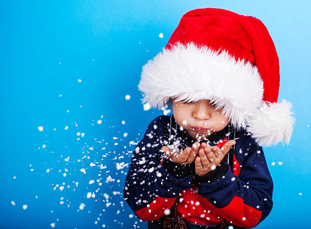 남자아이 산타 클로스 모자 불기 snowflakes - fake snow santa claus christmas christmas decoration 뉴스 사진 이미지