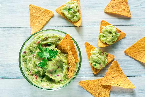 schüssel guacamole mit tortilla-chips - guacamole stock-fotos und bilder