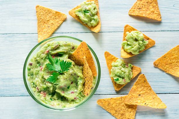 Bowl of guacamole with tortilla chips Bowl of guacamole with tortilla chips dipping sauce stock pictures, royalty-free photos & images