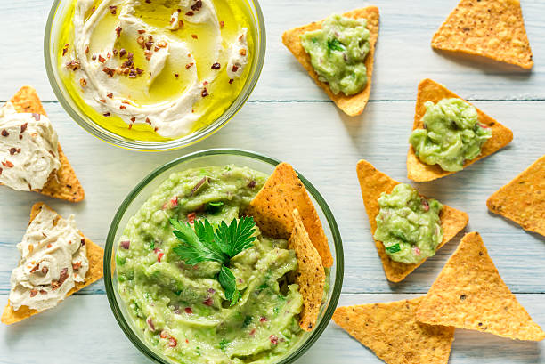 istock Bowls of hummus and guacamole with tortilla chips 618557028