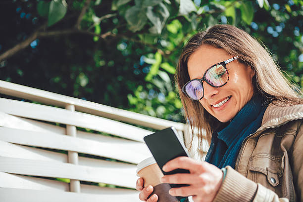istock Woman holding takeaway coffee and using smart phone 618608194