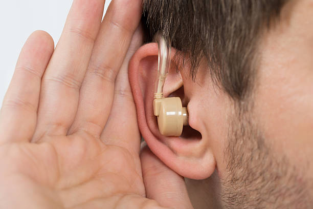 istock Close-up Of Man Wearing Hearing Aid In Ear 618609510