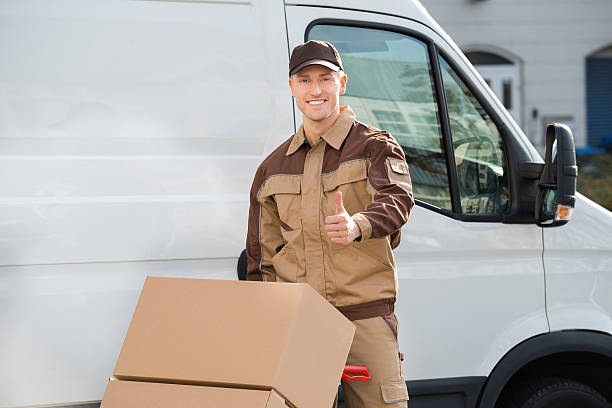 istock Confident Delivery Man Pushing Parcels On Handtruck 618609970