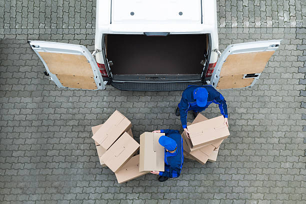 consegna uomini scarico scatole di cartone da camion su strada - scaricare foto e immagini stock