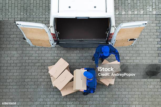 Delivery Men Unloading Cardboard Boxes From Truck On Street Stock Photo - Download Image Now