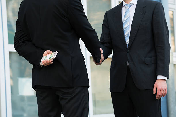 istock Businessman Holding Dollars While Shaking Hands With Partner 618610894