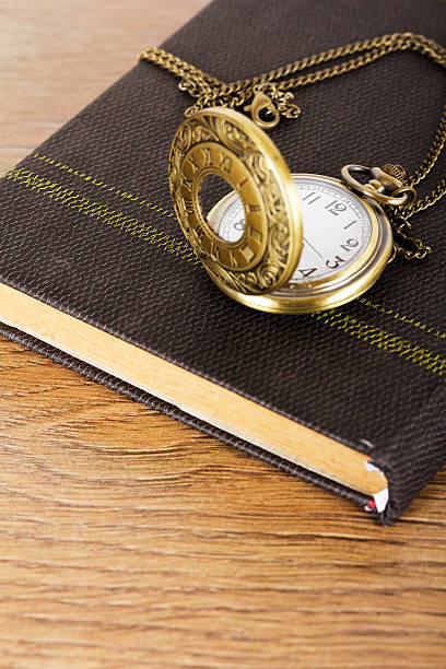 istock Pocket watch and book against a rustic background 618616512