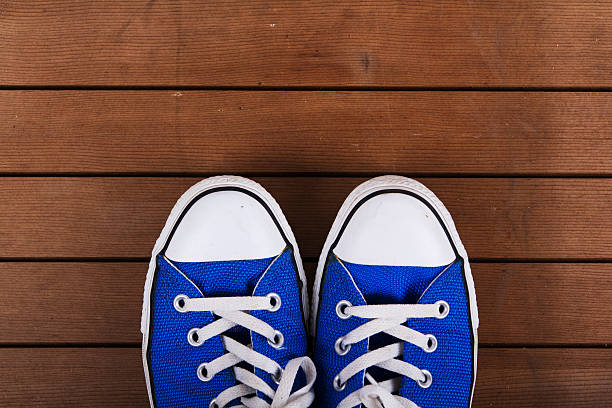 istock Old canvas shoes on a wooden floor 618621542