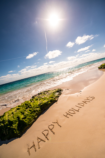 Happy Holidays written on sand, Bermuda beach