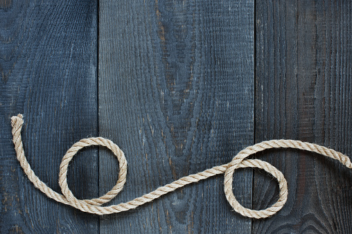 Twisted rope on the old wooden background