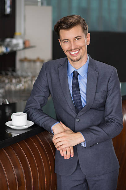 istock Smiling Businessman Leaning on Cafe Counter 618624142