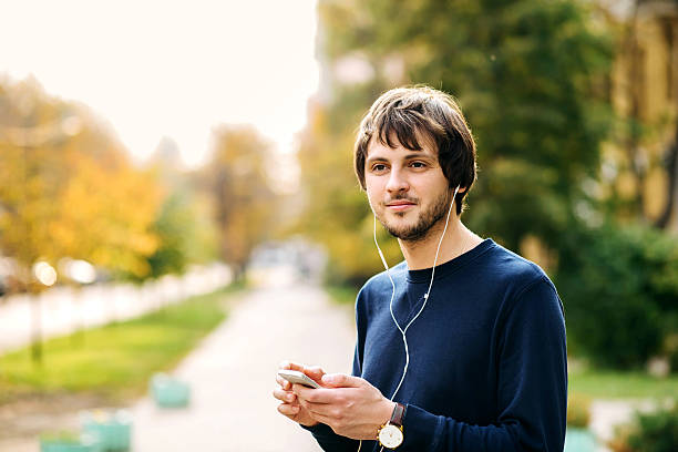 istock Happy young man walking and using a smart phone 618624580