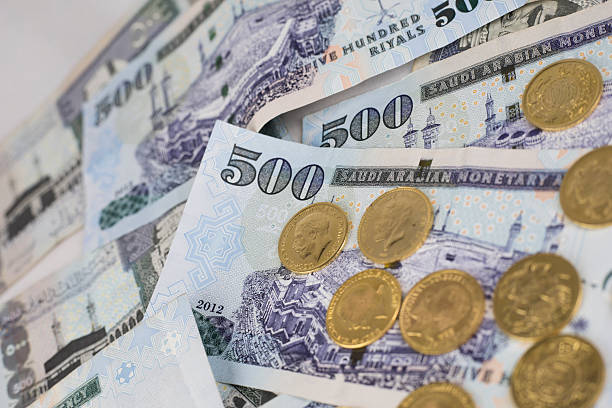 istock Gold coins sprinkled on five hundred riyal 618625568