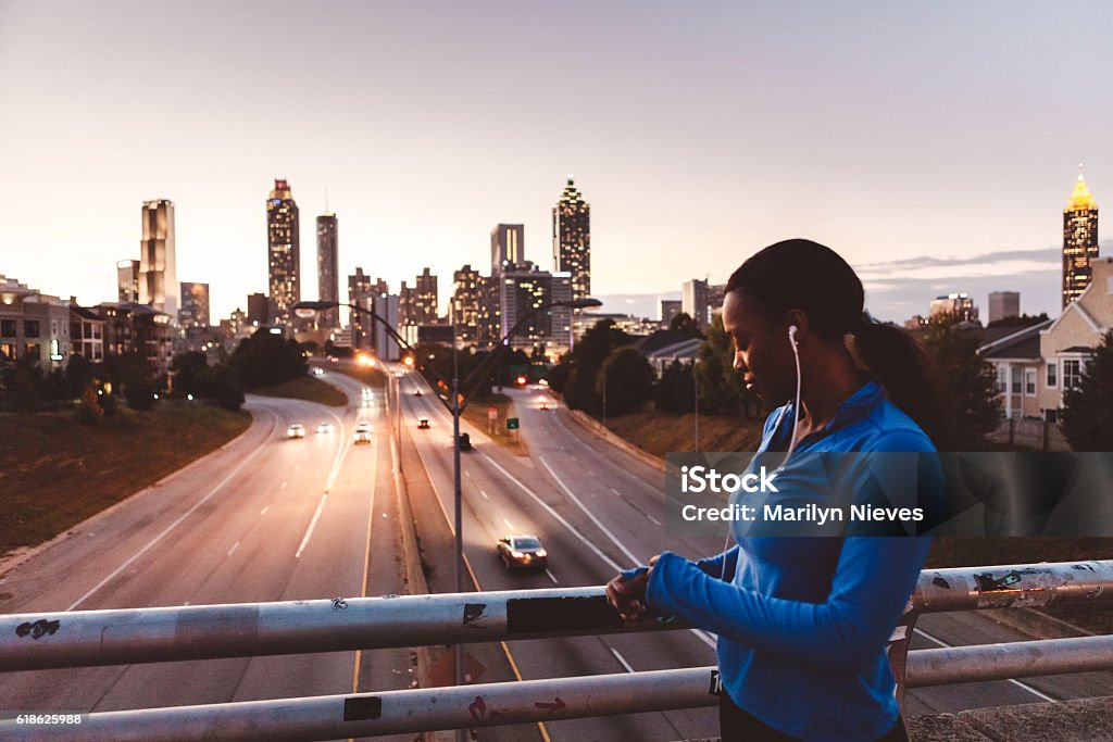 woman preparing for a run in the city Young women running fast through the city at night. Atlanta - Georgia Stock Photo