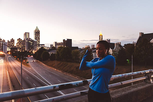 istock woman jogger stretching with skyline in the background 618626018