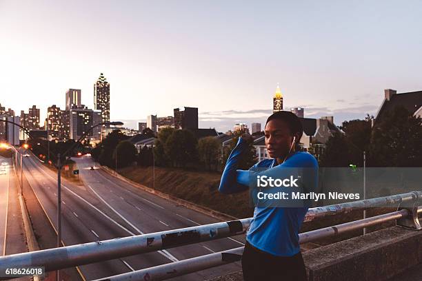 Woman Jogger Stretching With Skyline In The Background Stock Photo - Download Image Now