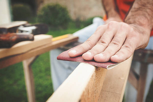 Sandblasting a wooden board close up shot Outdoor portraits of young man cutting painting and repairing wooden boards. Shallow DOF. Developed from RAW; retouched with special care and attention; Small amount of grain added for best final impression. 16 bit Adobe RGB color profile. sand paper stock pictures, royalty-free photos & images