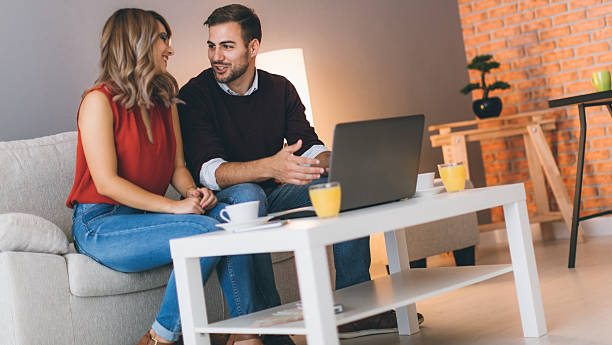 istock Cheerful couple at home using laptop 618627362