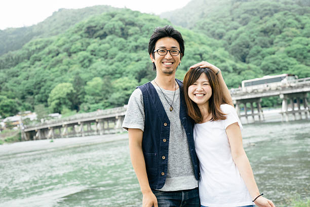 retrato de um casal japonês alegre ao ar livre em um parque - togetsu kyo bridge - fotografias e filmes do acervo