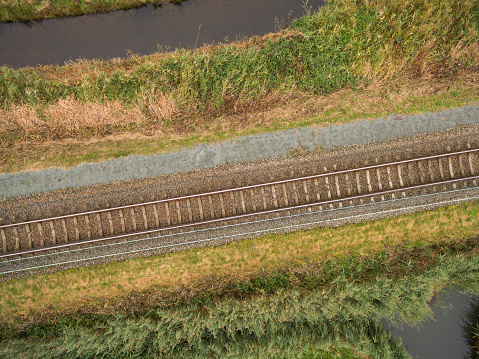 aerial view of green geometric agricultural field with railway in Netherlands