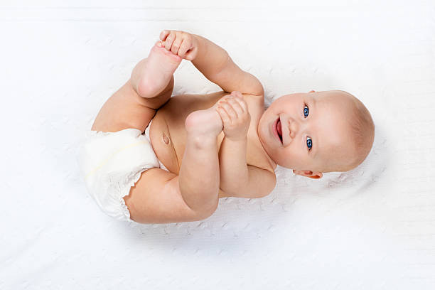 bebê usando fralda brincando em cobertor branco de malha - newborn little girls baby lying down - fotografias e filmes do acervo