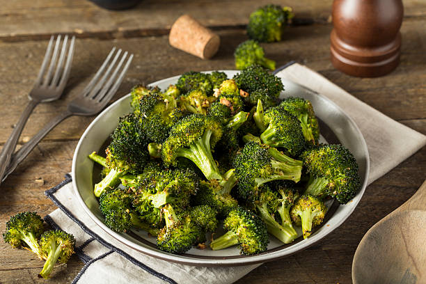 Organic Green Roasted Broccoli Florets Organic Green Roasted Broccoli Florets with Garlic cooking with garlic stock pictures, royalty-free photos & images