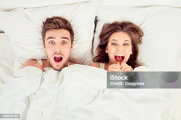 Sorprendida Pareja Divertida Enamorada Tumbada En La Cama Foto de stock y más banco de imágenes de Sexo y reproducción